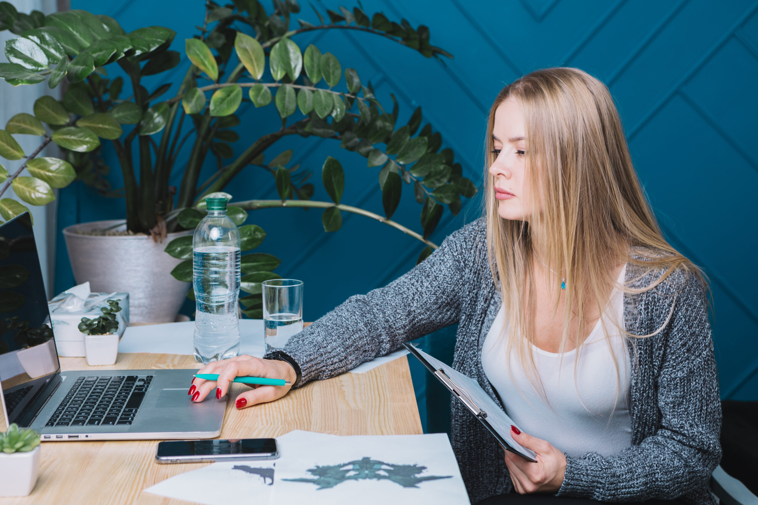young-blonde-female-psychologist-using-laptop-clinic